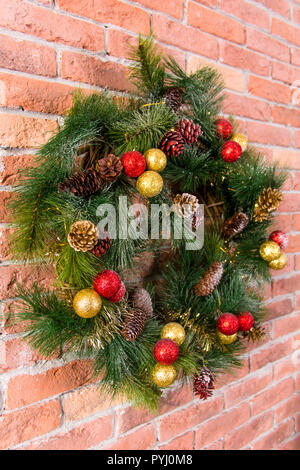 Decorative Christmas wreath with toys on a brick wall Stock Photo