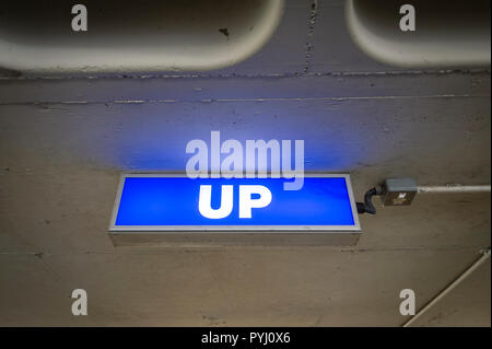blue illuminated 'UP' sign in a car park Stock Photo