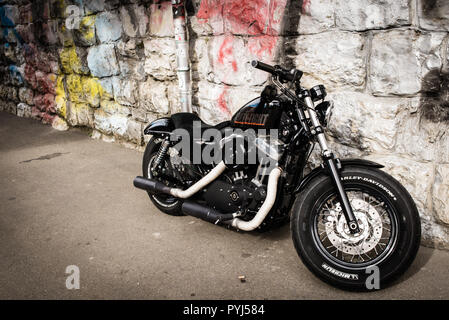 Zurich, Switzerland - March 2017: Black motorcycle 2017 Sportster Forty-Eight, motorbike Harley-Davidson with stone wall and graffiti in background Stock Photo