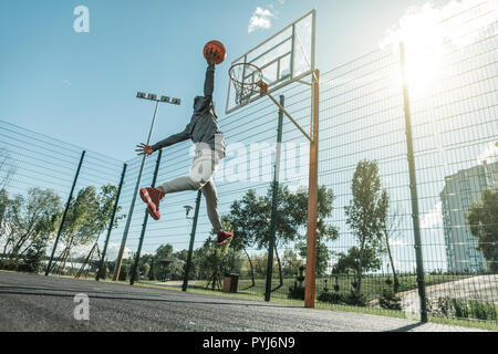 Low angle of a nice young man throwing the ball Stock Photo