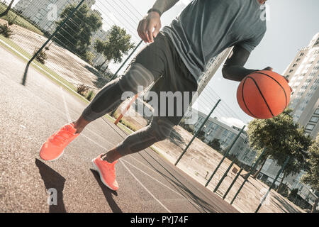 Well built nice man playing basketball alone Stock Photo