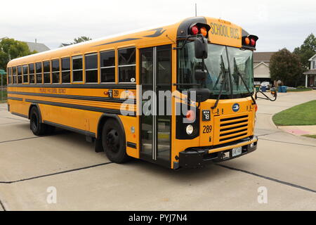 School Bus picking up students in a suburban neighborhood Stock Photo