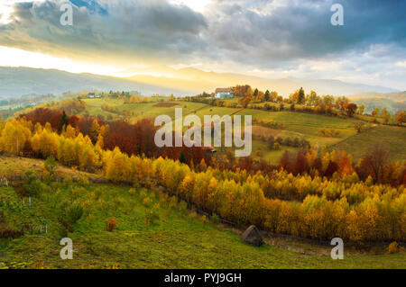 Hills and mountains bathed in warm sunset light in Poiana Marului, Romania. Magic autumn sunset landscape Stock Photo