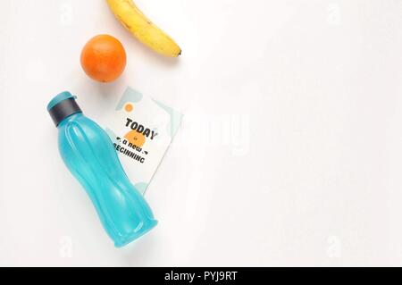 Attributes of a healthy lifestyle: food, sports and athlete's equipment on white background with motivated phrase. Flat view with copy space. Eco bott Stock Photo