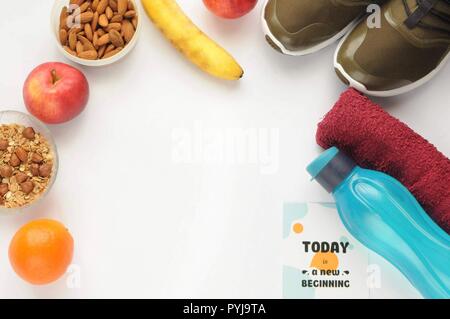 Attributes of a healthy lifestyle: food, sports and athlete's equipment on white background with motivated phrase. Flat view with copy space. Eco bott Stock Photo