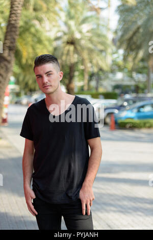 Young handsome man standing in the parking lot Stock Photo