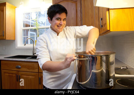 https://l450v.alamy.com/450v/pyjc64/person-in-a-chef-jacket-stirs-a-huge-vat-of-soup-or-stew-with-a-wooden-spoon-over-the-stove-pyjc64.jpg
