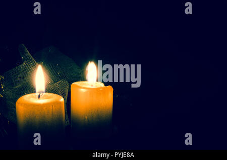 two burning candles against black background Stock Photo