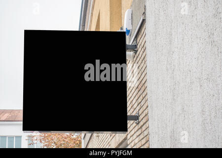 Mock up of blank black rectangular signboard on the wall Stock Photo