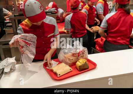 New York, USA. 28th Oct, 2018. Workers hurry to prepare orders in the Jollibee fast food restaurant in Midtown Manhattan in New York on opening day Saturday, October 27, 2018 . The restaurant chain, which has been dubbed the Philippine McDonald's because of its ubiquity and popularity in the country, opened its first location to Manhattan in the Times Square area. Jollibee Foods Corp., which has plans to open hundreds of stores in the U.S. and Canada also holds a stake in the Smashburger chain. (Â© Richard B. Levine) Credit: Richard Levine/Alamy Live News Stock Photo