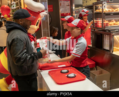 New York, USA. 28th Oct, 2018. Workers hurry to prepare orders in the Jollibee fast food restaurant in Midtown Manhattan in New York on opening day Saturday, October 27, 2018 . The restaurant chain, which has been dubbed the Philippine McDonald's because of its ubiquity and popularity in the country, opened its first location to Manhattan in the Times Square area. Jollibee Foods Corp., which has plans to open hundreds of stores in the U.S. and Canada also holds a stake in the Smashburger chain. (© Richard B. Levine) Credit: Richard Levine/Alamy Live News Stock Photo