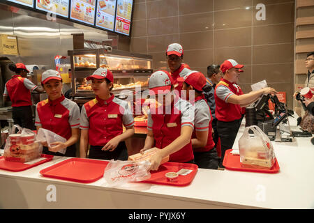 New York, USA. 28th Oct, 2018. Workers hurry to prepare orders in the Jollibee fast food restaurant in Midtown Manhattan in New York on opening day Saturday, October 27, 2018 . The restaurant chain, which has been dubbed the Philippine McDonald's because of its ubiquity and popularity in the country, opened its first location to Manhattan in the Times Square area. Jollibee Foods Corp., which has plans to open hundreds of stores in the U.S. and Canada also holds a stake in the Smashburger chain. (Â© Richard B. Levine) Credit: Richard Levine/Alamy Live News Stock Photo