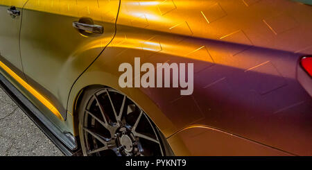 Car with chekered yellow paint and black tire rim Stock Photo