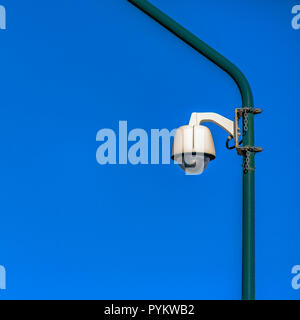 White dome security camera on a green pole Stock Photo