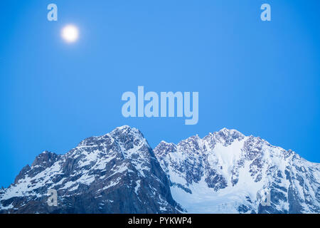 Full moon above Mount Disgrazia. Chiareggio, Valmalenco, Valtellina, Lombardy, Italy, Europe. Stock Photo