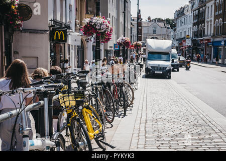 London, UK - August 1, 2018: Bicycles chained to a railing in Richmond, a suburban town in south-west London famous for a large number of parks and op Stock Photo