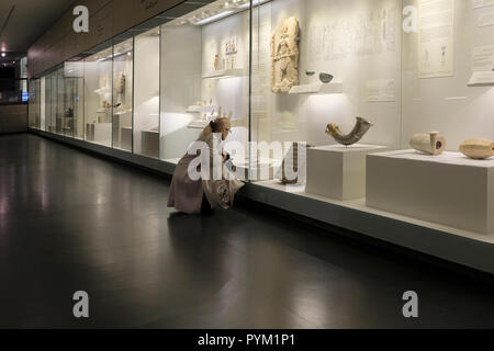 A visitor looking at exhibits displayed at the Archeology Wing in the Israel Museum in West Jerusalem Israel Stock Photo