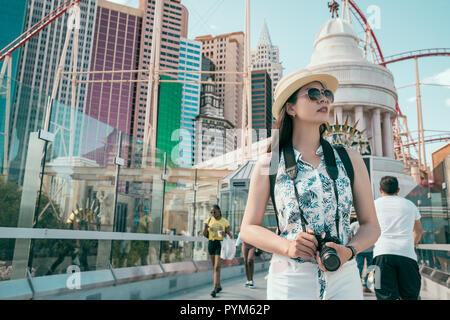young travel photographer enjoy the urban view in las vegas. theme park in the background in USA. red roller coaster is opening in summer vacation. Stock Photo