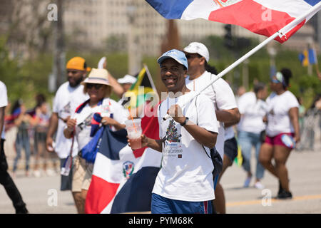 Chicago, Illinois, USA - June 16, 2018: The Puerto Rican Day Parade, Man holding the Dominican Flag during the parade Stock Photo