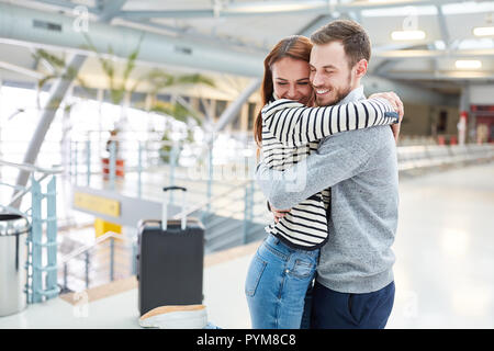 Young happy man hugs his wife while reunion in the airport Terminal Stock Photo