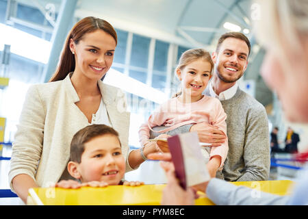 Family and service agent at the check-in desk in the airport terminal at the passport control Stock Photo