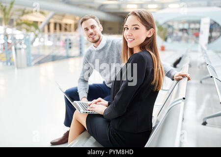 Young businesswoman before a business trip in the airport. Terminal with laptop computer Stock Photo