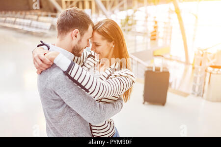 Happy couple hugs each other at the welcome meeting at the airport Stock Photo