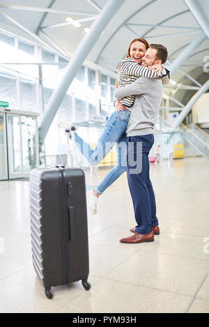 Young woman is picked up by her husband at the airport and looks forward to seeing him again Stock Photo