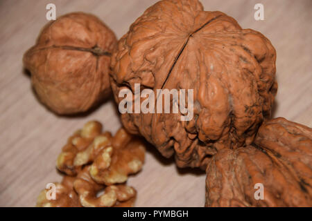 juglans regia top view, whole walnuts and walnut kernels on structured wooden background Stock Photo