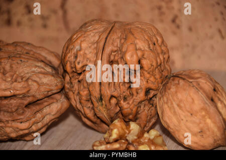 healthy organic juglans regia, whole walnuts and walnut kernels on structured wooden background Stock Photo
