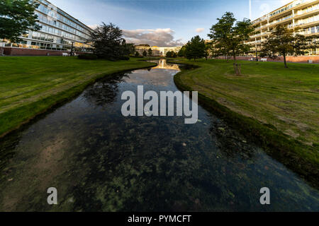 Two high and long appartement buildings bordering and reflecting on a little canal in The Hague, Netherlands Stock Photo