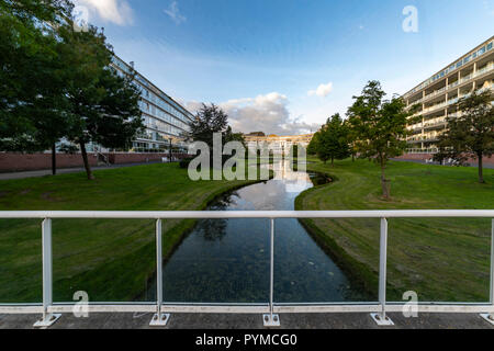 Two high and long appartement buildings bordering and reflecting on a little canal in The Hague, Netherlands Stock Photo