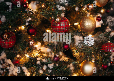 Close up of decorated Christmas pine with red and gold checkered bows and ribbons.  Stock Photo