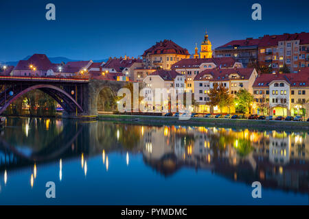 Maribor, Slovenia. Cityscape image of Maribor, Slovenia during autumn twilight blue hour with reflection of the city in Drava River. Stock Photo