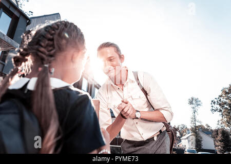 Stylish modern father with tattoo on hand taking his little girl to school Stock Photo