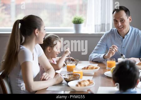 Happy attractive family having healthy breakfast sitting in the  Stock Photo