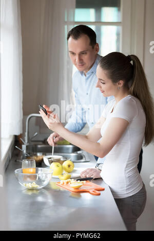 Couple standing in the kitchen cooking together Stock Photo