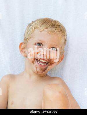 Portrait of fair-haired boy with chocolate on his face isolated on white background,baby boy smile Stock Photo