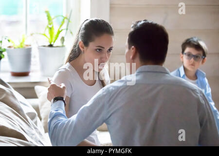 Unhappy couple with little preschool son at home quarrelling Stock Photo