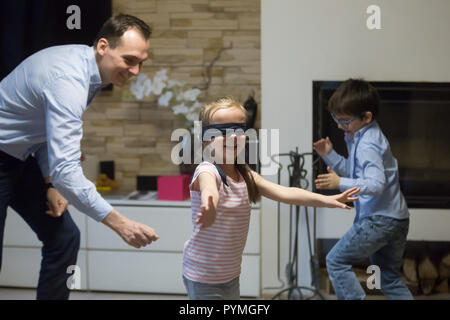 Single father with little kids playing hide and seek  Stock Photo