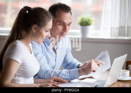 Satisfied wife and husband checking bills at home Stock Photo