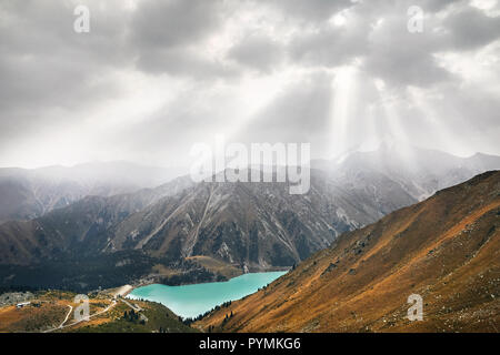Beautiful landscape of crystal clear lake surrounded by mountains at overcast sky in Almaty, Kazakhstan Stock Photo