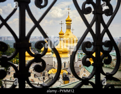 Church with golden domes behind the fence at Kiev Pechersk Lavra Christian complex. Old historical architecture in Kiev, Ukraine Stock Photo
