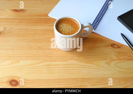 Cup of Hot Coffee with a Notebook and Cellphone on Wooden Working Desk, Free Space for Design and Text Stock Photo