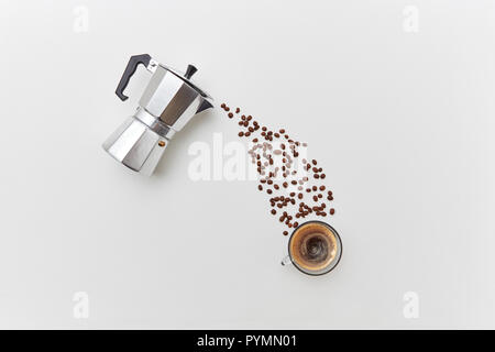 Fragrant coffee beans in the form of a pouring drink from italian metal coffee maker on a gray background with copy space. Flat lay Stock Photo