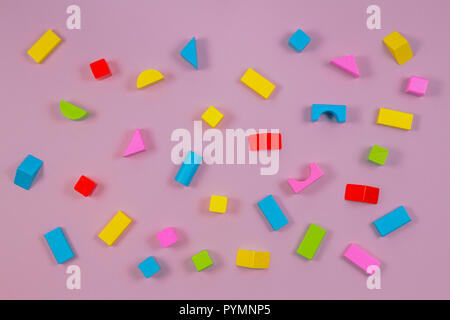 Colorful wooden building blocks on pink background Stock Photo