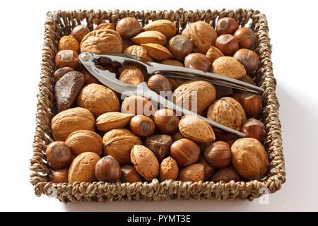 Mixed nuts in a woven basket with nut cracker Stock Photo