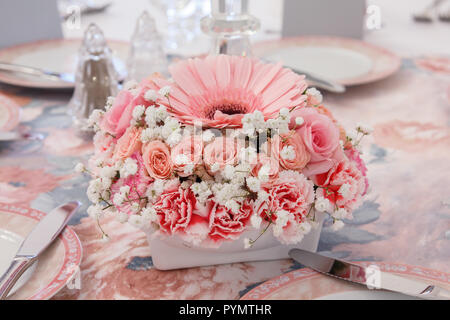 Historical delicate many shades of pink flower arrangement on table Stock Photo