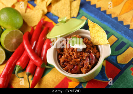 Chili con carne with nachos on tablecloth in spanish pattern Stock Photo