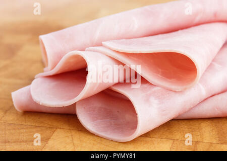 Processed ham randomly arranged on chopping board. Stock Photo
